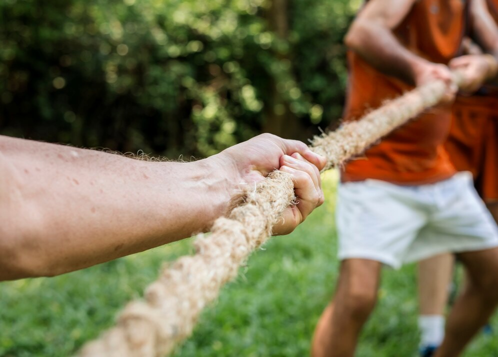 Tug of War showing three men pulling at a rope